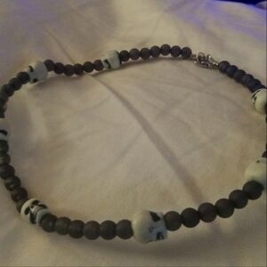 A gray necklace with white skulls accent